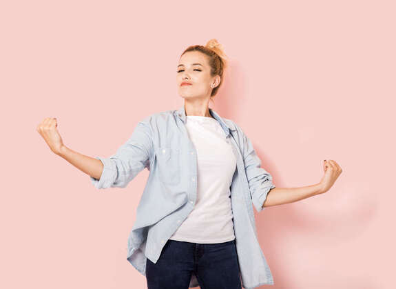 Selbstbewusste Frau steht vor rosa Hintergrund