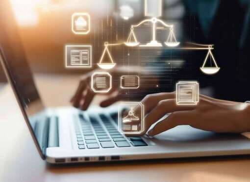 Hände, die einen Laptop bedienen, im Vordergrund Icons mit Rechtssymbolen