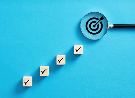 Kleine Würfel mit einem Haken, die in Treppenform nach oben gelegt wurden.